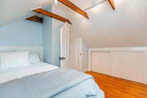 Schlafzimmer mit einem weißen Bett und Holzböden in der Unterkunft Hill & Harbor Cove House in East Greenwich