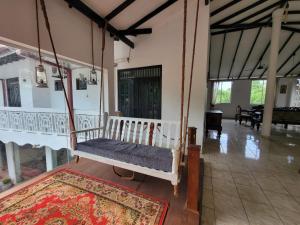 a swinging bed in a room with a rug at The Empyrean Airport Transit Hotel in Katunayake