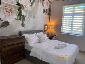 a bedroom with a bed with two towels on it at Homestay Desaru Rock House in Bandar Penawar