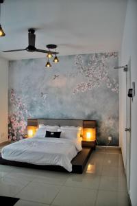 Bandar PenawarにあるHomestay Desaru Rock Houseの壁に絵が飾られた大きなベッドのある寝室