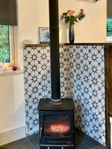 a stove in a room with a tile wall at Railway cottage Annascaul in Anascaul