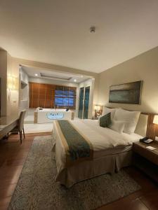a bedroom with a large bed and a bath tub at Best Western Plus Buraidah in Buraydah +47 photos