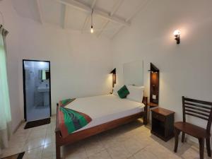 a bedroom with a bed and a chair at The Empyrean Airport Transit Hotel in Katunayake