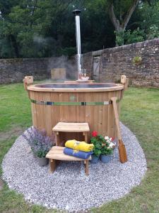 a hot tub with a bench and a fountain at Secret Garden Shepherd Hut in Macclesfield