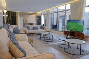 利雅德sawt hadeer - صوت هدير的配有沙发和平板电视的客厅