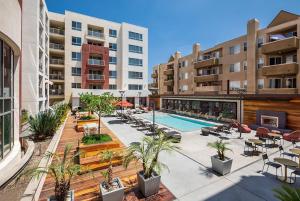 an apartment complex with a pool and chairs and buildings at Luxury Apartment West Hollywood in Los Angeles