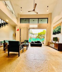 ein großes Wohnzimmer mit einem Sofa und einem Stuhl in der Unterkunft NzoStay Casa Cobble Luxury Villa Alibaug in Alibag