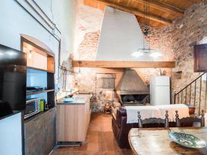 a kitchen with a couch and a table in a room at Masovería Ca la Maria in Arbúcies