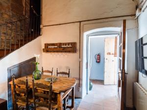 a dining room with a wooden table and chairs at Masovería Ca la Maria in Arbúcies