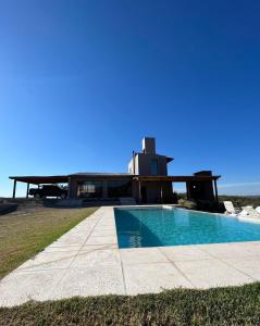 uma casa com uma piscina em frente em el buen aire em La Pampa