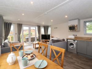 a kitchen and living room with a table and a dining room at Meadowsweet Lodge in Carnforth