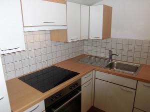 a small kitchen with white cabinets and a sink at Appartements Haus Schmalzl in Viehhofen