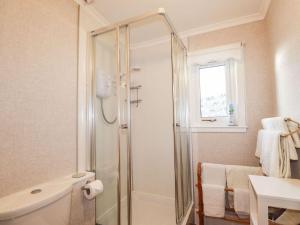 a bathroom with a shower and a sink at Rose Cottage in Strathpeffer
