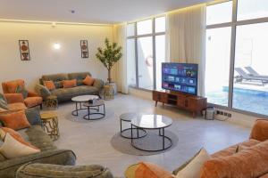 a living room with couches and a flat screen tv at Hadeer Chalet in Riyadh
