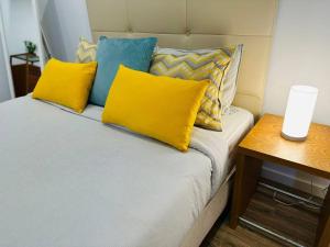 a bed with yellow and blue pillows and a table at Casa Branca Apartment in Funchal in Funchal