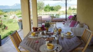 a wooden table with food on top of a patio at Chambre d'hôtes Ananda in Sisteron