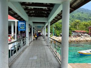 Eine Brücke über das Wasser, auf der Leute herumlaufen. in der Unterkunft Perhentian Suria in Perhentian Island