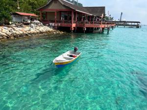 a small boat in the water near a dock at Perhentian Suria in Perhentian Island