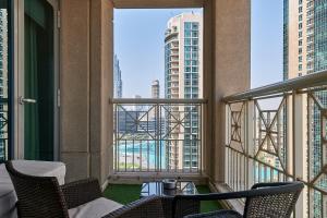 a balcony with chairs and a view of the city at Bellavista - Striking - 1BR with Extra Twin Room - 29 boulevard - Partial Fountain View in Dubai