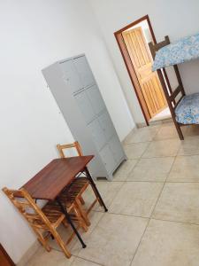 una habitación con una silla de madera y una tabla en la pared en Hostel Dela, en Tiradentes