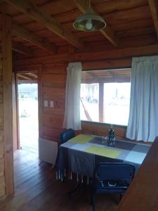 una sala da pranzo con tavolo in una cabina di Cabaña El Cardenal a Tandil