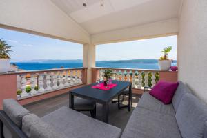 a balcony with a couch and a table at Apartments Lucija in Crikvenica