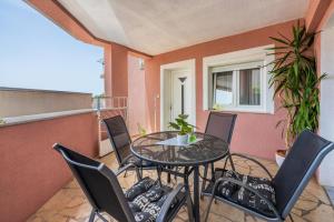 a patio with a table and chairs on a balcony at Apartments Lucija in Crikvenica