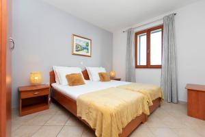 Postel nebo postele na pokoji v ubytování Apartments Ljiljana