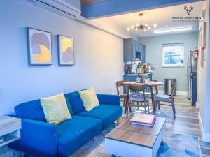 uma sala de estar com um sofá azul e uma mesa em The Moose #5 - Modern Comfy Studio with King Bed, Free Parking & Fast WiFi em Memphis