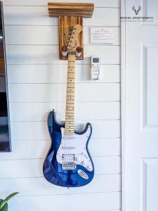 a guitar hanging on a wall at The Moose #5 - Modern Comfy Studio with King Bed, Free Parking & Fast WiFi in Memphis