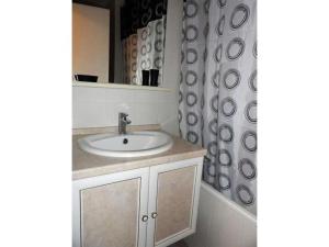 a bathroom with a sink and a shower curtain at Cauterets centre - Résidence Le marcadau 1 in Cauterets