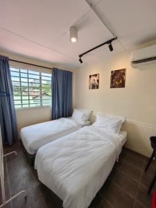 two beds in a room with blue curtains at WW Hostel 22A Private Shower in George Town