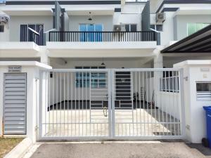 a white gate in front of a house at Homestay Desaru Rock House in Bandar Penawar