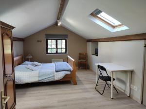 um quarto com uma cama, uma secretária e uma clarabóia em Appartement Gaston em Vireux-Wallerand