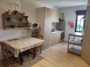 uma cozinha com uma mesa e uma cozinha com uma mesa e cadeiras em Appartement Gaston em Vireux-Wallerand