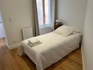 a bedroom with a bed with two towels on it at Les Hortensias in Épernay +9 photos