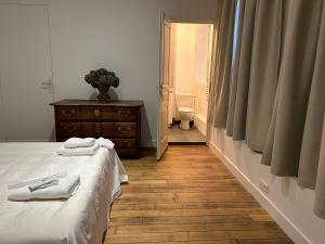 a bedroom with a bed and a bathroom with a toilet at Les Hortensias in Épernay