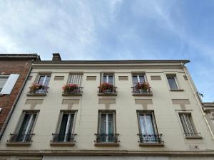 a building with windows and flower boxes on it at Les Hortensias in Épernay