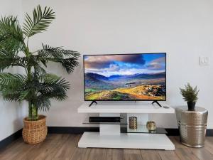 a flat screen tv sitting on top of a white stand at *Msg for 5%off*2Bed1Bath QueenBeds NorthPHX in Phoenix