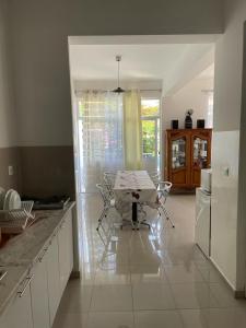 une cuisine avec une table et des chaises. dans l'établissement Maison Residencial casa de ferias, à Pedra Badejo