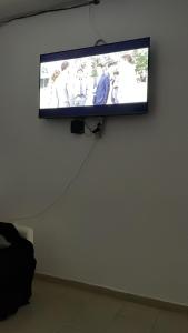 a flat screen tv hanging on a wall at Maison Residencial casa de ferias in Santa Cruz