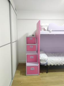 - un lit superposé rose avec quatre tiroirs dans une chambre dans l'établissement Moderno piso con vista a la playa, à Puebla de Farnals