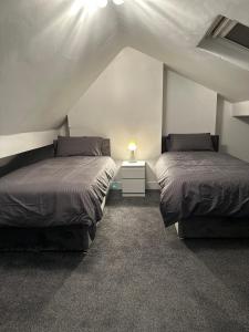 two beds in a room with a attic at 5-Bed Apartment in Altrincham near airport in Altrincham