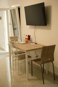 een houten tafel met stoelen en een televisie aan de muur bij B & B CANTARANO in Porto Garibaldi