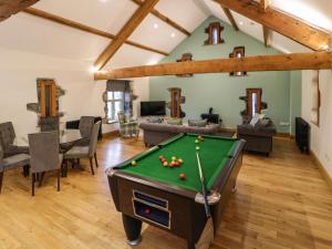 a living room with a pool table in the middle at The Barn by Lyons in Talybont