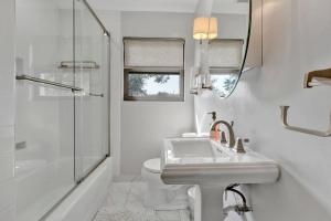 y baño blanco con lavabo y ducha. en The Modern Bungalow at Mimosa, en Memphis