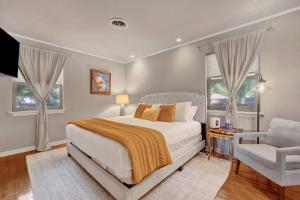 1 dormitorio con 1 cama, 1 silla y ventanas en The Modern Bungalow at Mimosa, en Memphis