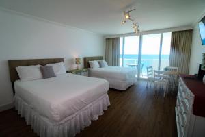 een hotelkamer met 2 bedden en een tafel en stoelen bij Balcony studio with Ocean View in Miami Beach