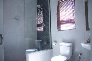 a bathroom with a toilet and a shower and a sink at Palapye Guest House in Palatswe