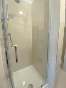 y baño con ducha y puerta de cristal. en Gower street residences en Londres
